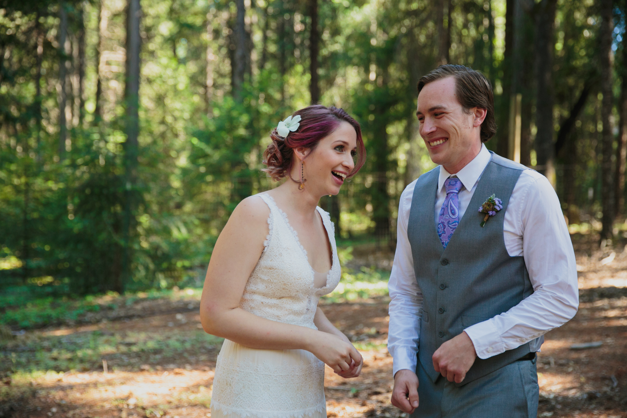 Bride and groom laughing in the woods.