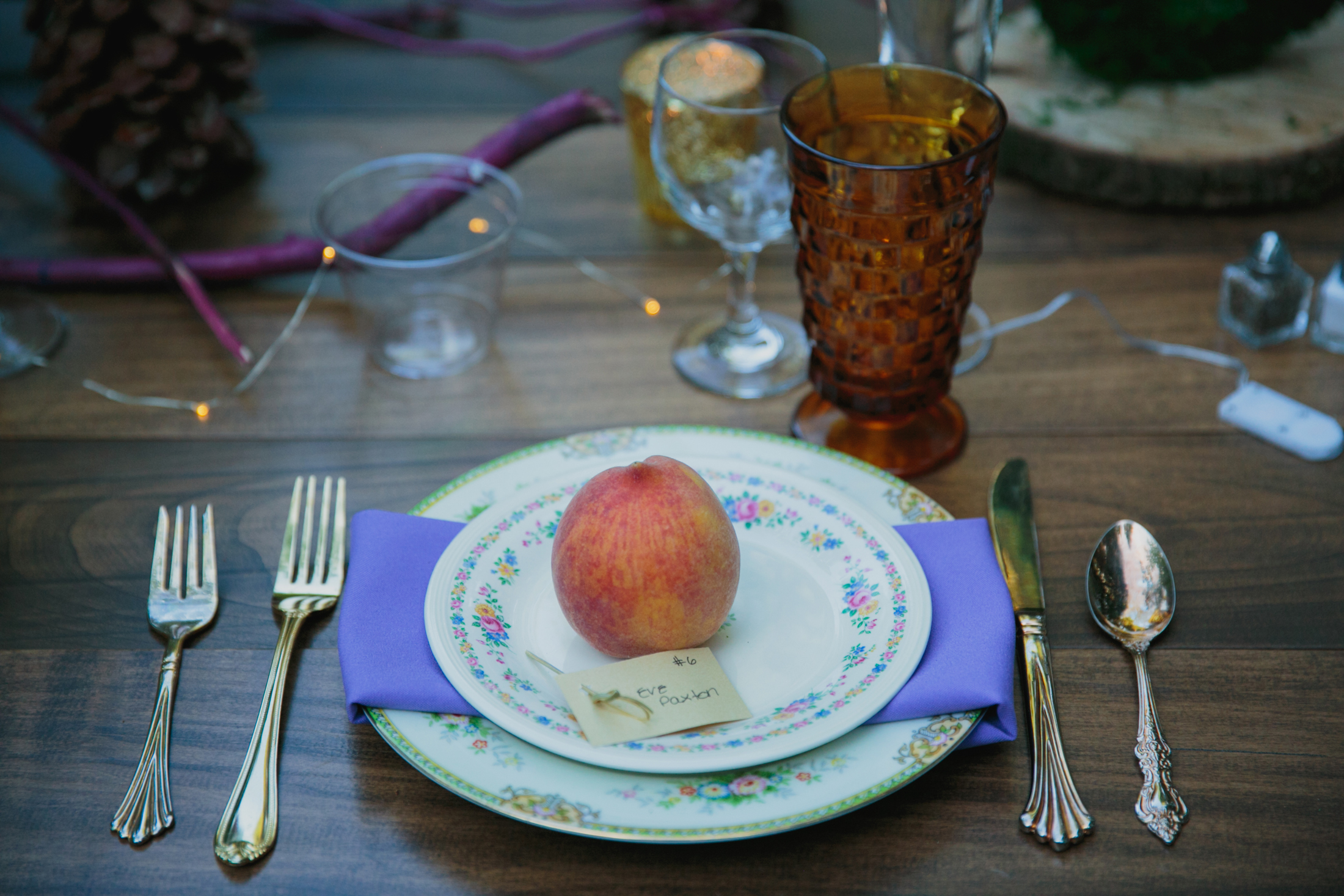 A single place-setting with a ripe peach on the vintage plate.