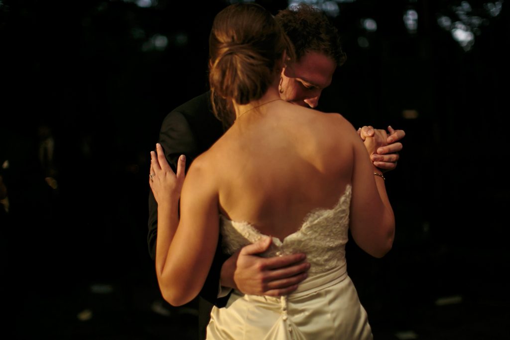 An up-close view from behind the bride as the groom holds her during their first dance.
