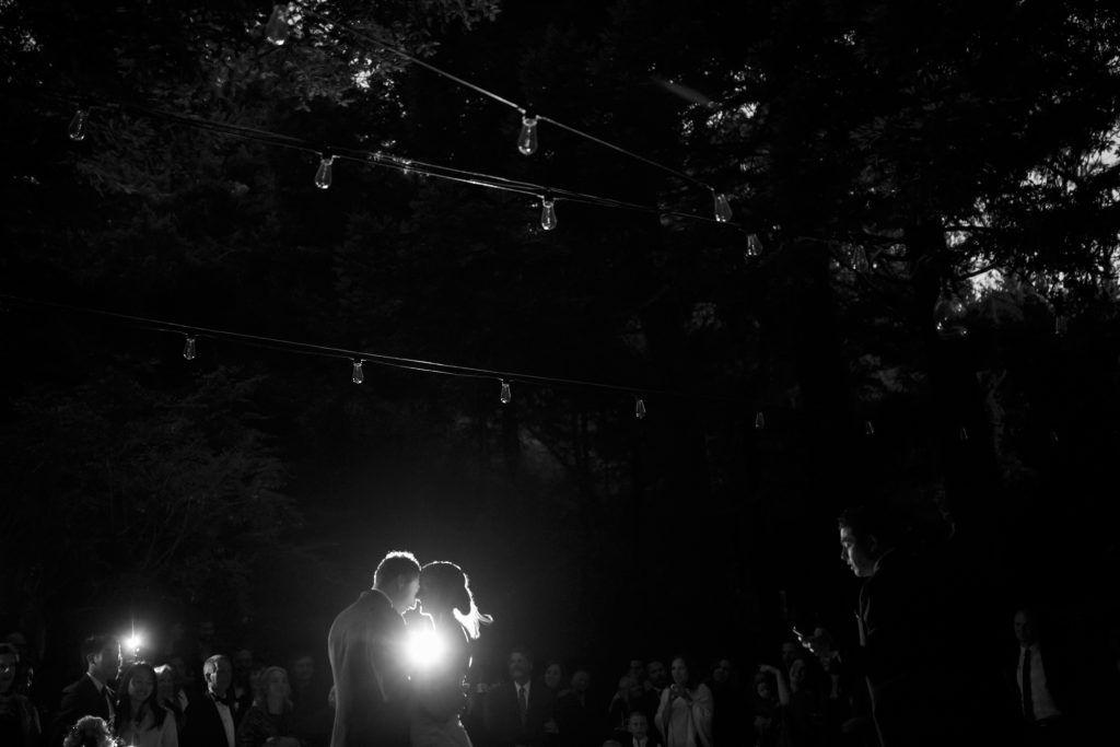 A light shines between the bride and groom and illuminates their silhouettes.